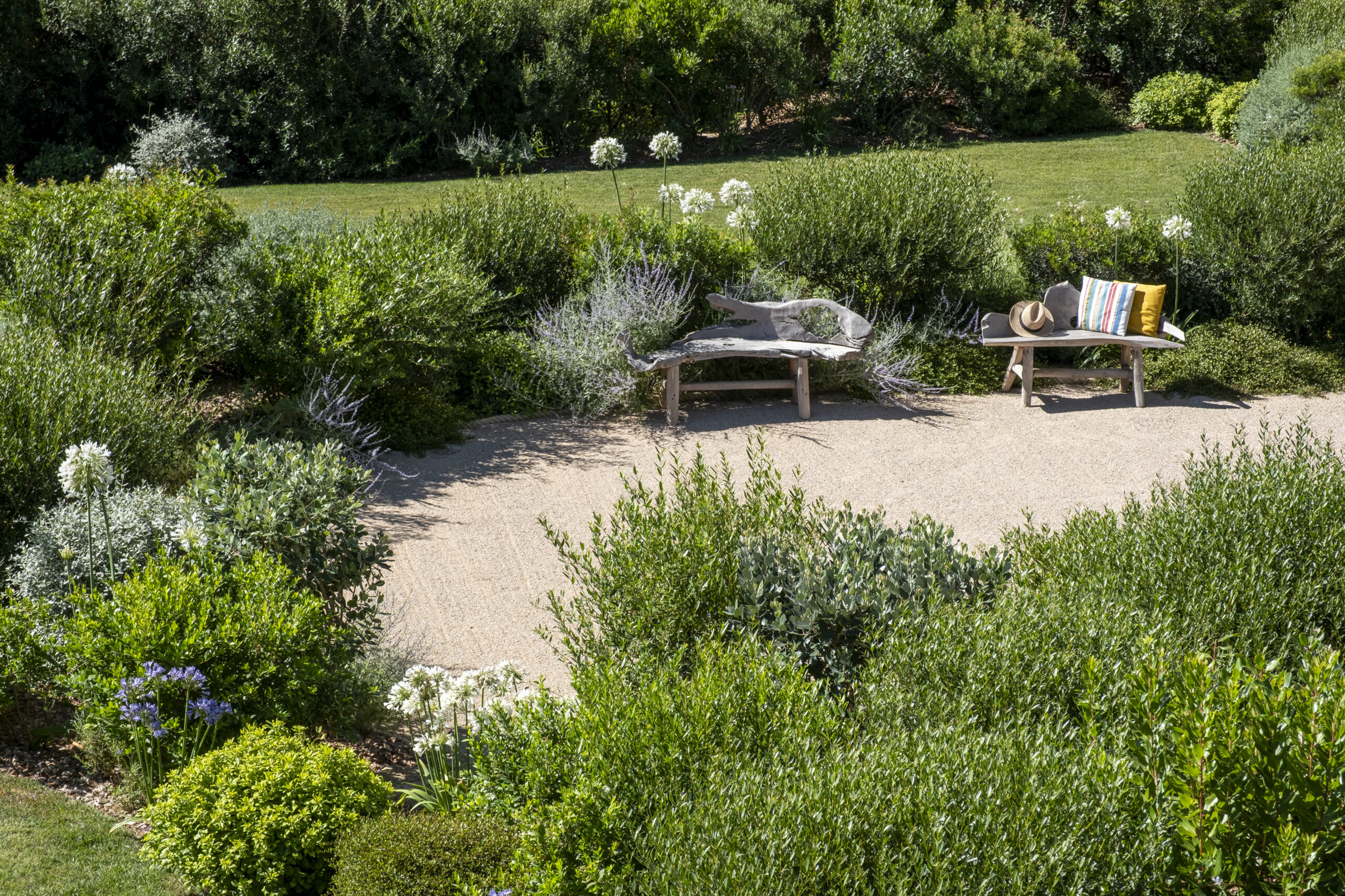 Banquettes en bois sur gravier Banquettes en bois et massifs fleuris dans un jardin méditerranéen par MR Paysage