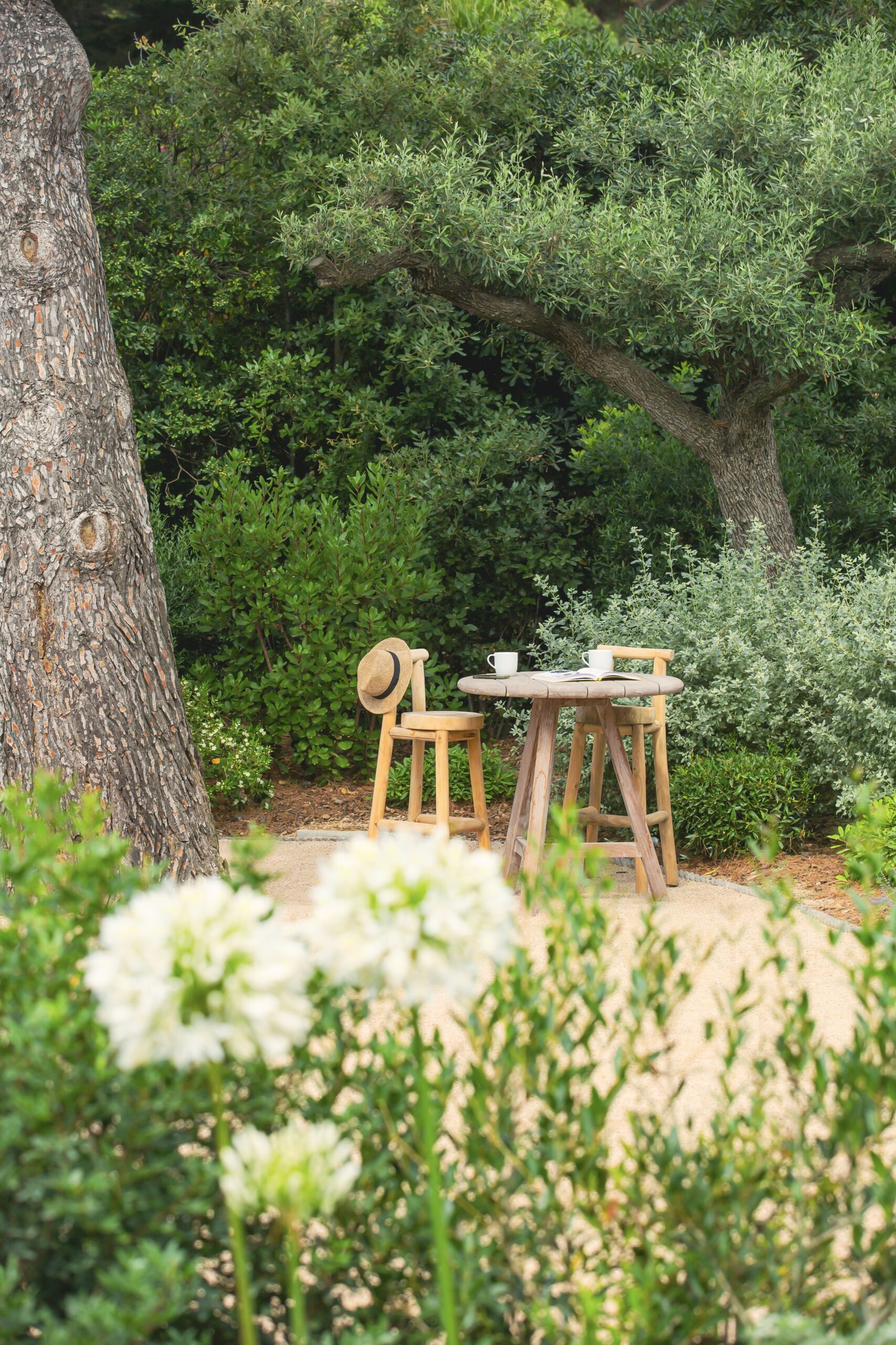 Coin bistrot en bois — pause au jardin Coin bistrot en bois et chapeau de paille dans un jardin paysager par MR Paysage